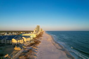 Beautiful view of a sandy Orange beach with modern buildings of the Gulf of Mexico, Alabama